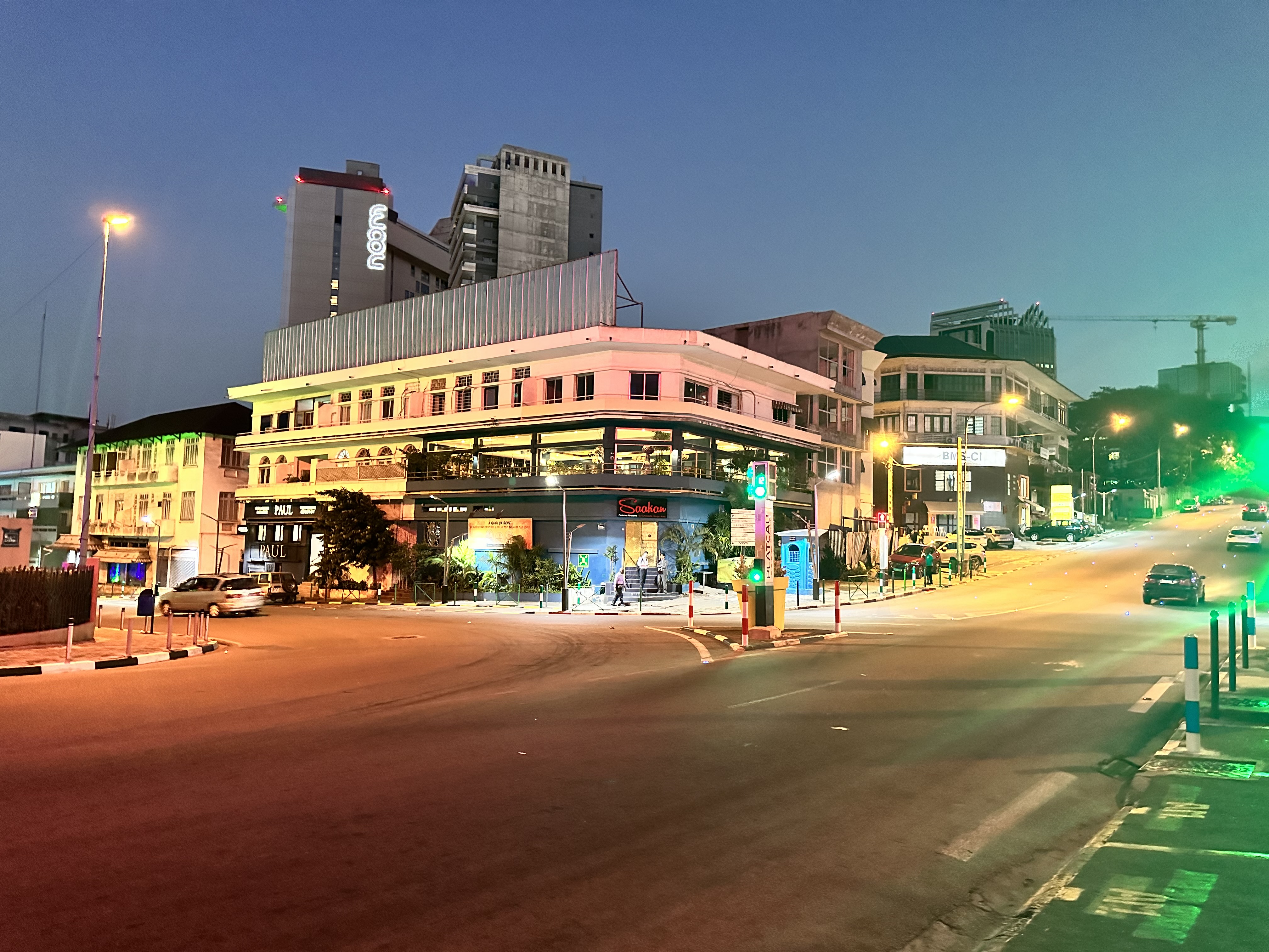 Rue d’Abidjan à la tombée du jour, commerces éclairés et circulation